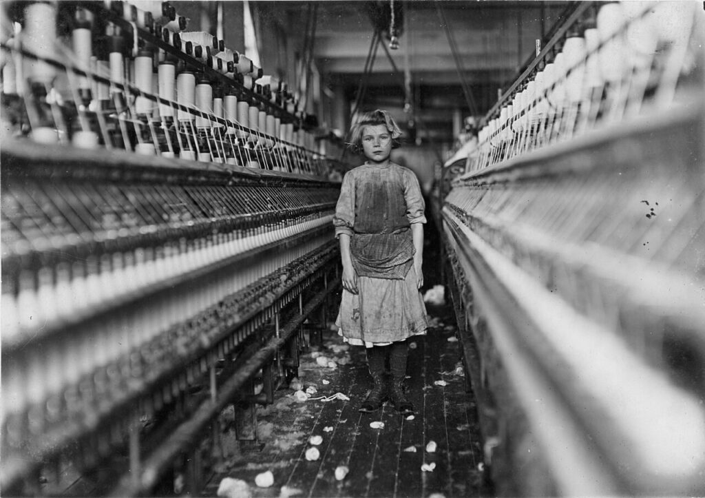 Treball infantil a una fàbrica tèxtil (Lewis Hine, c. 1908). El proletariat industrial inclou nens.